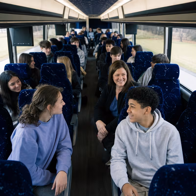 Group boarding a white charter bus for School Transportation transportation in Pembroke Pines
